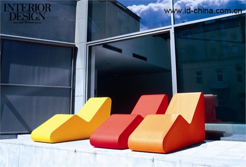 色彩浓烈的椅子与露台的灰色调对比。